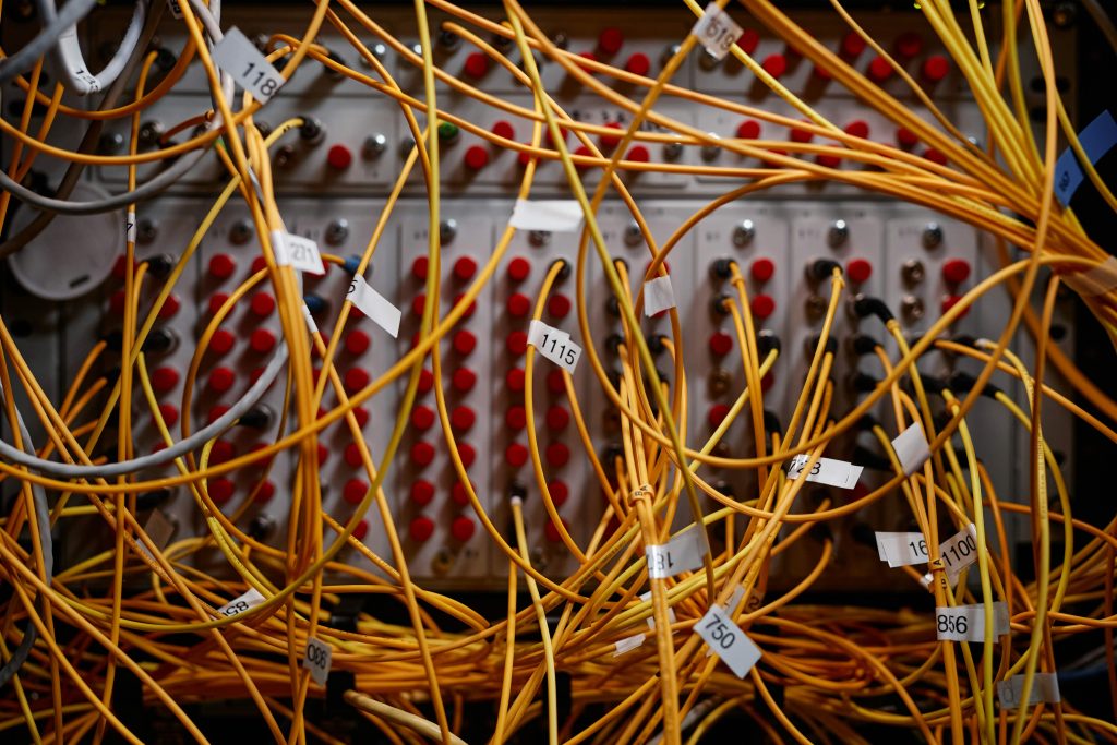 Tangled wires converging into a single organized cable — visual metaphor for turning an unconscious business operating system into an intentional one