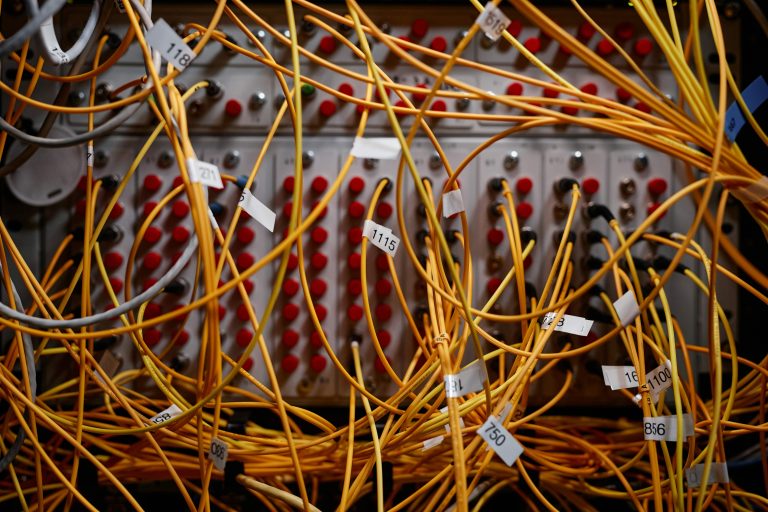 Tangled wires converging into a single organized cable — visual metaphor for turning an unconscious business operating system into an intentional one